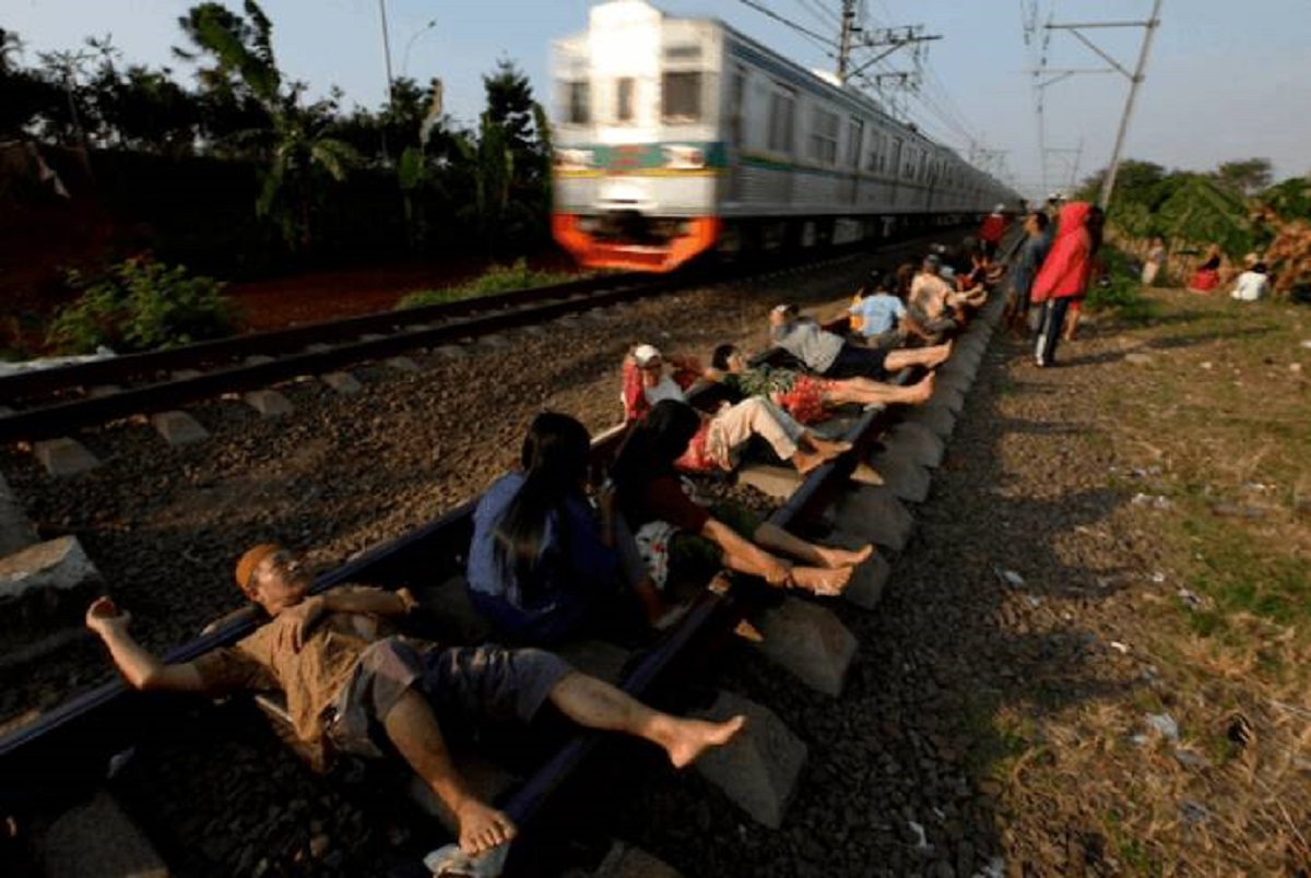 “In Rawa Buaya, West Java, Indonesians lay on tracks, believing the energy would heal their illnesses”