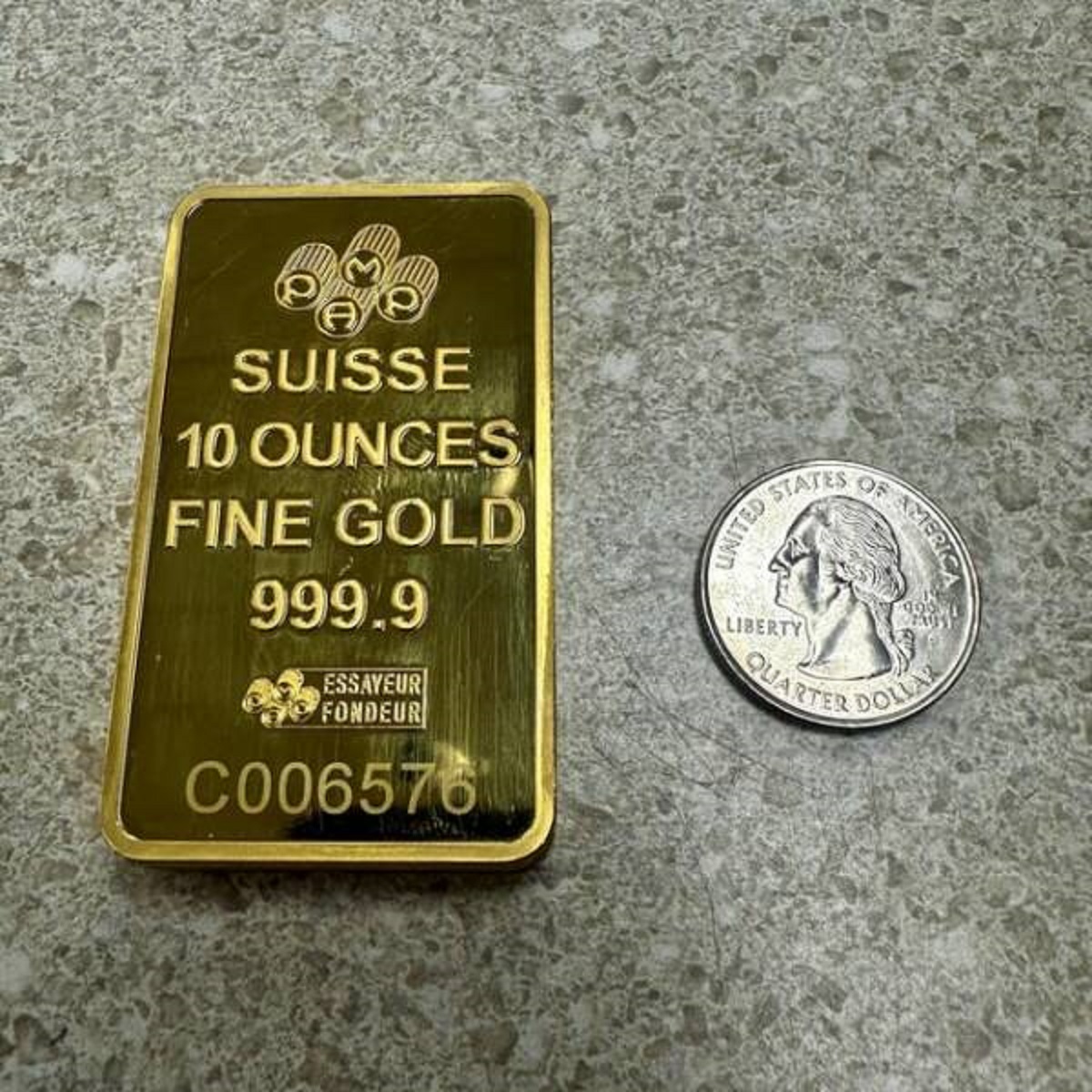 "$26,500 Gold Bar, quarter for scale"