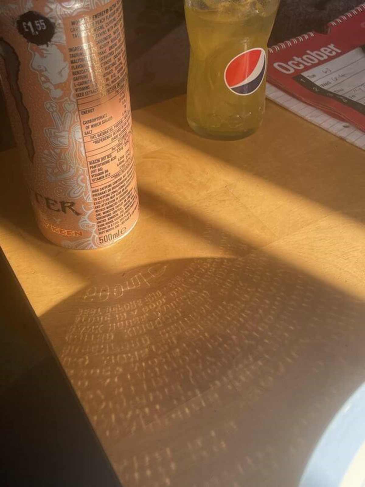 "The sun reflecting the text on my can of Monster onto the table"