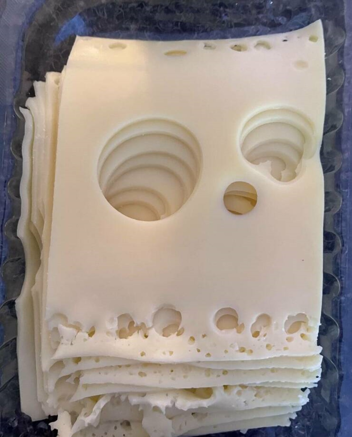 "Opened cheese slices pack today and was greeted by this spooky fellow…"