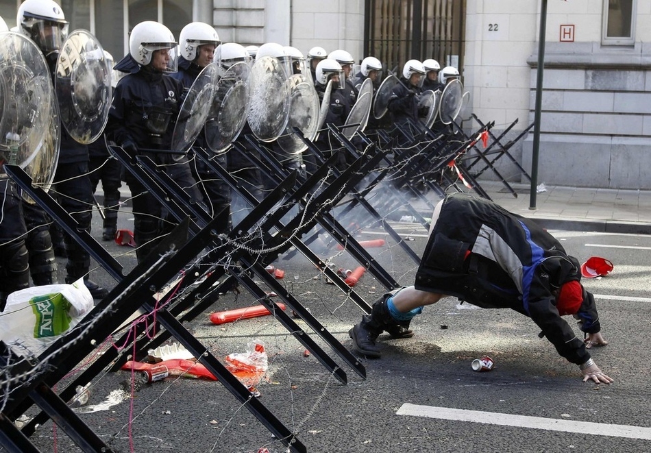 A demonstrator shows his bottom to riot police during a protest by European workers and trade union representatives to demand better job protection in the European Union countries in Brussels on March 24.