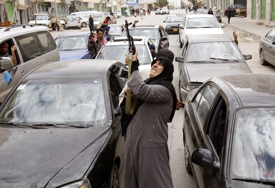 A woman rebel fighter supporter fires an AK-47 rifle as she reacts to the news of the withdrawal of Libyan leader Muammar Gaddafi's forces from Benghazi on March 19.