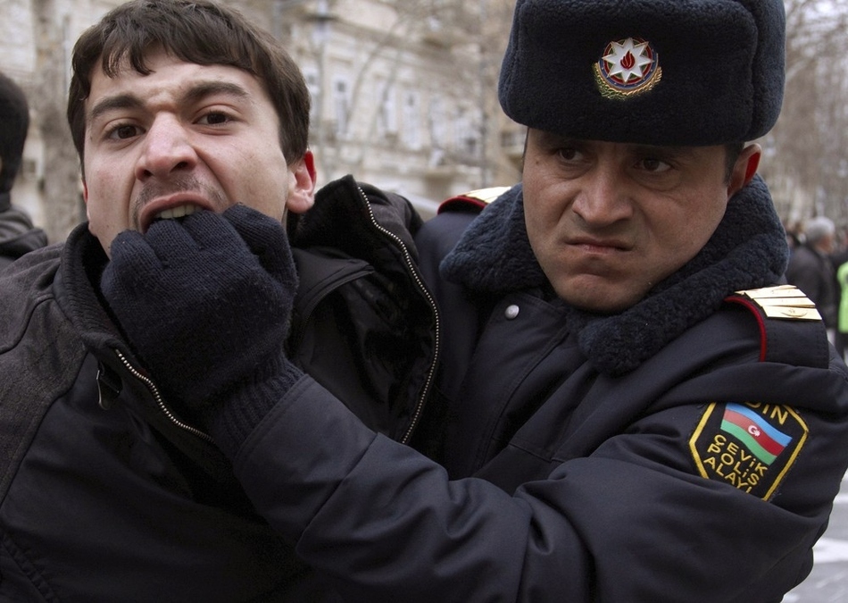 A policeman detains an opposition activist in Baku on March 12. Azerbaijan police detained more than 30 activists of the opposition Musavat Party when its members took to the street of Baku to protest against the ruling elite following a similar rally a day before.