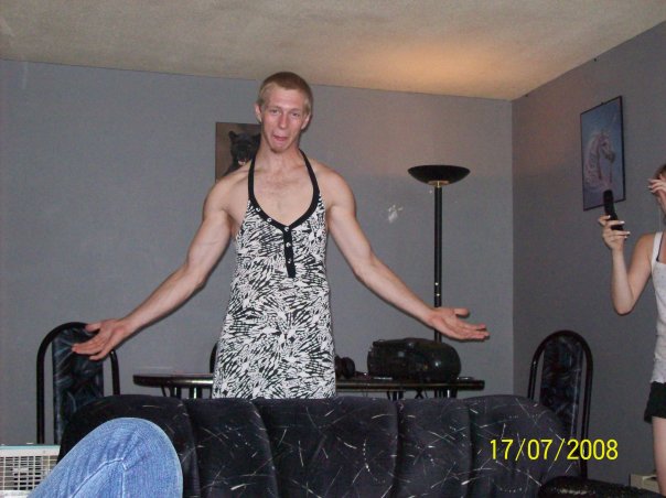A grown man in a dress. Very long and well built arms.