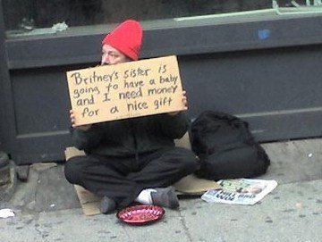 Homeless man holding a sign which i found to be very funny.