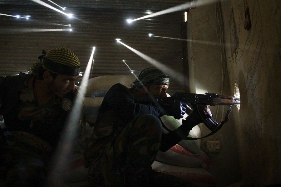 2013:  Javier Manzano – “Syrian Rebels.”  This picture was taken on Oct 18, 2012 and shows two rebel soldiers in Syria guarding their position in the Karmel Jabl neighborhood of Aleppo, as light streams through more than a dozen holes made by bullets and shrapnel in the tin wall behind them. The dust from more than one hundred days of shelling, bombing and firefights hung in the air. Karmel Jabl is strategically important because of its proximity to the main road that separates several of the main battlegrounds in the city.