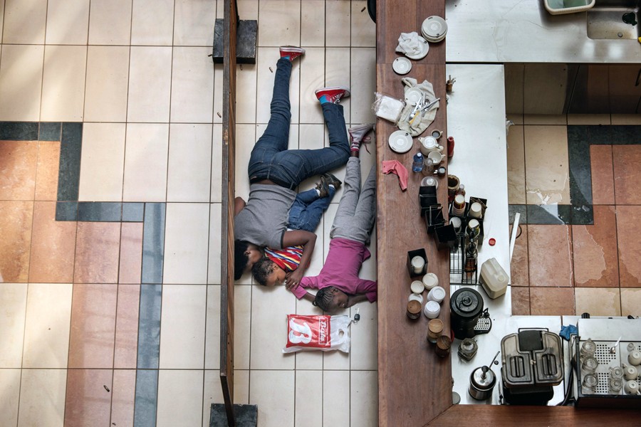 2014:  Tyler Hicks – “Westgate Mall in Kenya.”  For his compelling pictures that showed skill and bravery in documenting the unfolding terrorist attack at Westgate mall in Kenya. 
In this picture: A woman tried to shelter children from gunfire by Somali militants at the Westgate mall in Nairobi, Kenya, in an attack that killed more than 70 people. Tyler Hicks made this photo from a floor above, in an exposed area where the police feared for his safety.