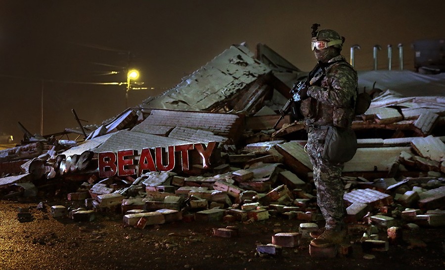 2015 Picture 4:  A Missouri National Guardsman stands over the rubble of Prime Beauty Supply in Ferguson. Though Gov. Jay Nixon had activated the guardsmen several days before the grand jury's verdict was announced, they were kept out of Ferguson until the following day.