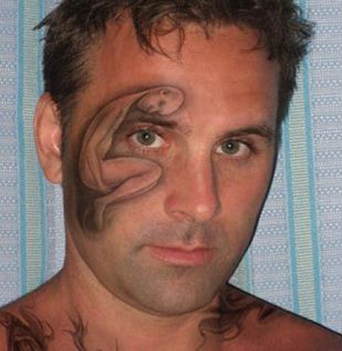man with tattoo on his face of a person in the fetal position.