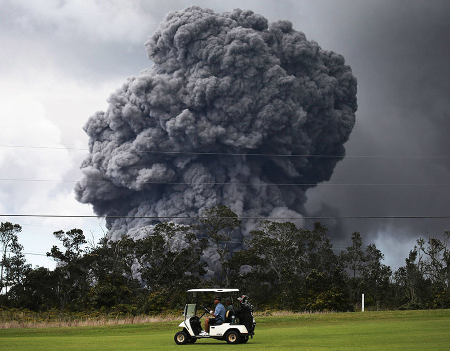 An ash cloud rises not far from a golf course.