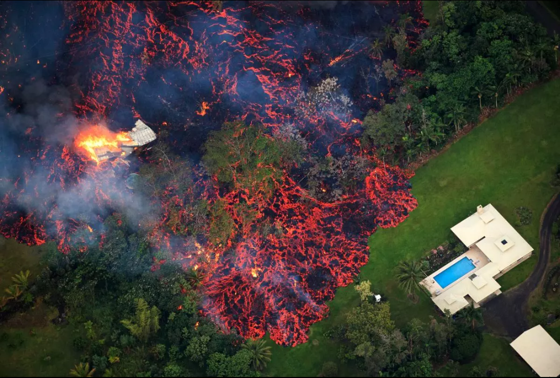 One home is destroyed while the lava flow encroaches on another.