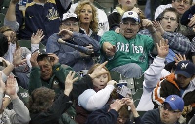 Milwaukee Brewers fans react as Yovanni Gallardo's bat goes flying into the stands 
