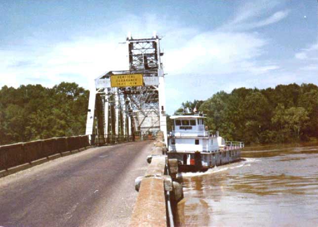 Tugboat rolls under bridge