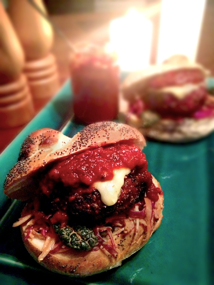 Organic Peppered Beef Burger with kale slaw, melted Gruyere and smoked rocoto chutney, on a poppy seed knot roll.