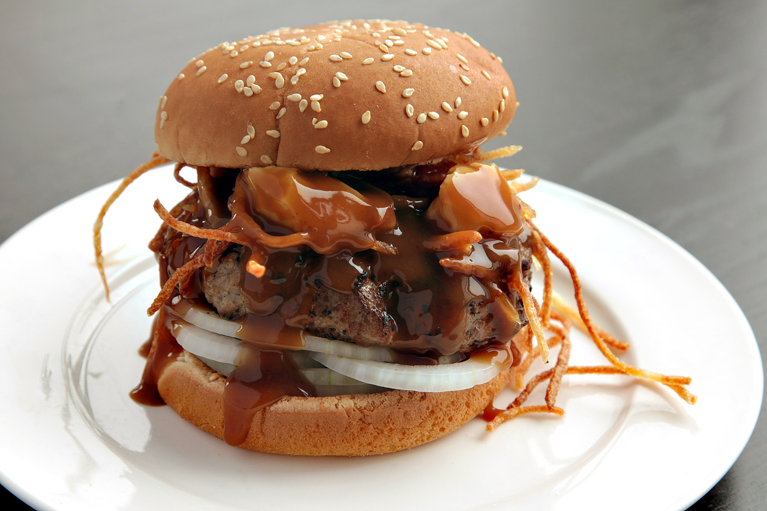 Poutine Burger, with fried onion strings and raw onions.