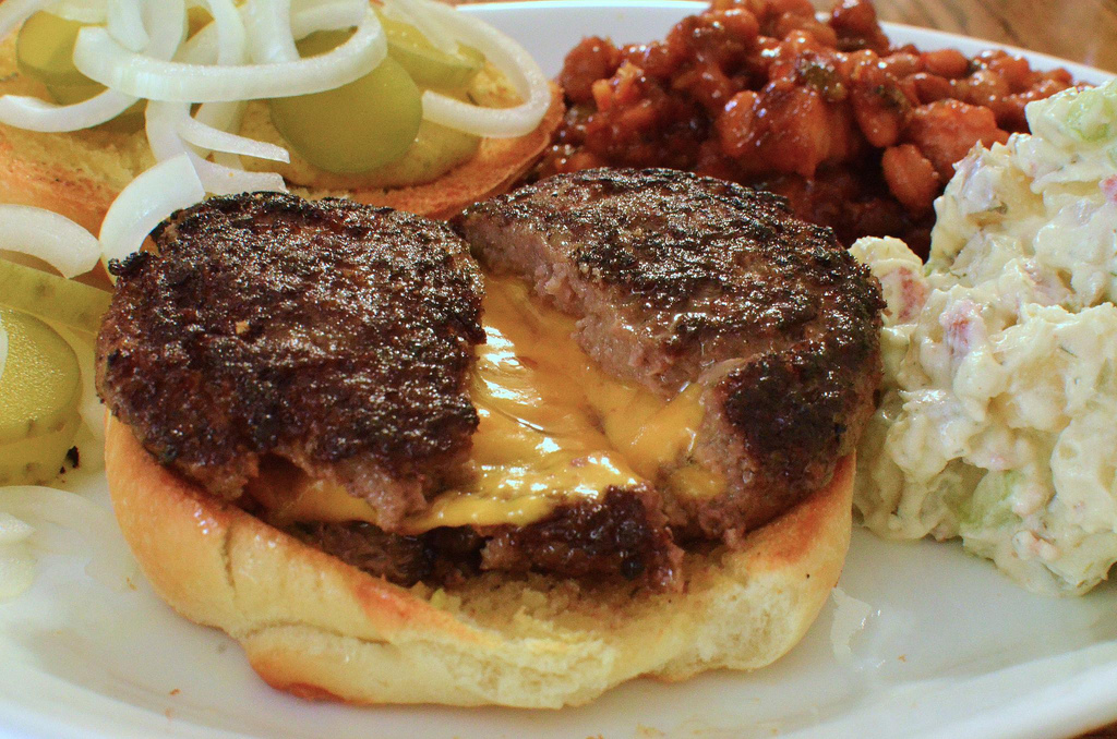 Cheddar Stuffed Burger with bacon, sour cream, potato salad, and baked  beans.