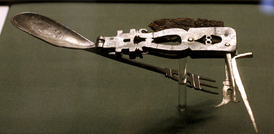 Ancient Roman folding multi-tool device. The tool features a knife, a spoon, a three-tined fork, a spike, a spatula, and a small pick.2nd century AD.