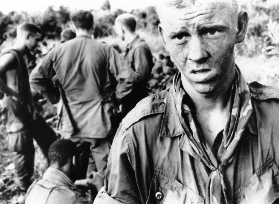 A young Paratrooper with a mud-smeared face stares into the jungle in Vietnam on July 14, 1966, after fire fight with Viet Cong patrol in the morning. He is a member of C Company, 2nd Battalion, 173rd Airborne Brigade.