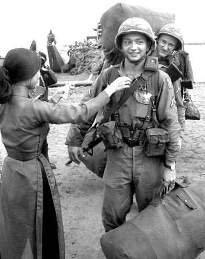 196th Light Infantry Brigade arrives in Vietnam, 1966. A soldier is given a flower by a Vietnamese girl.