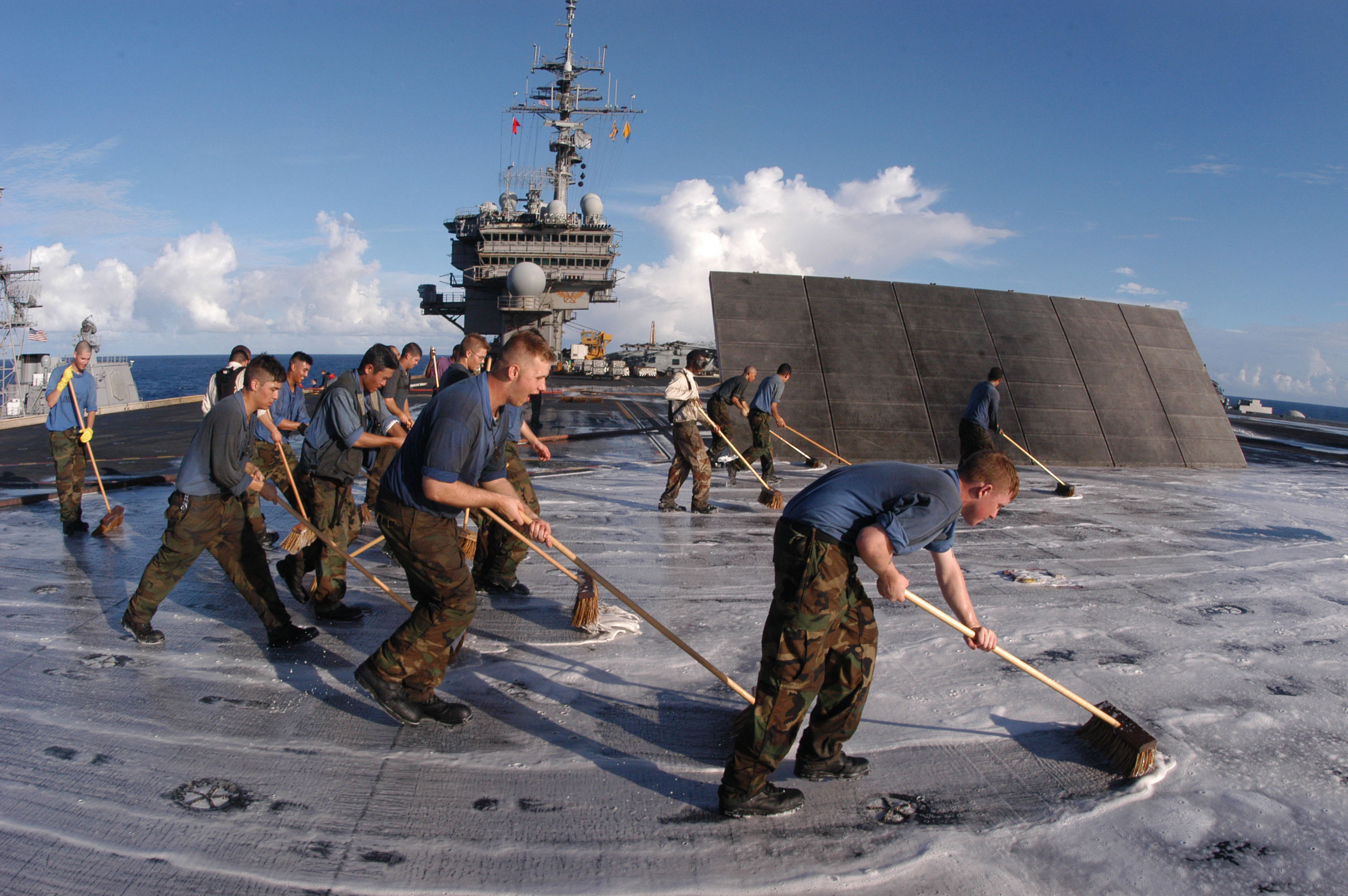 Airwing squadron members scrub the oil from the flight deck. This is done twice a week.