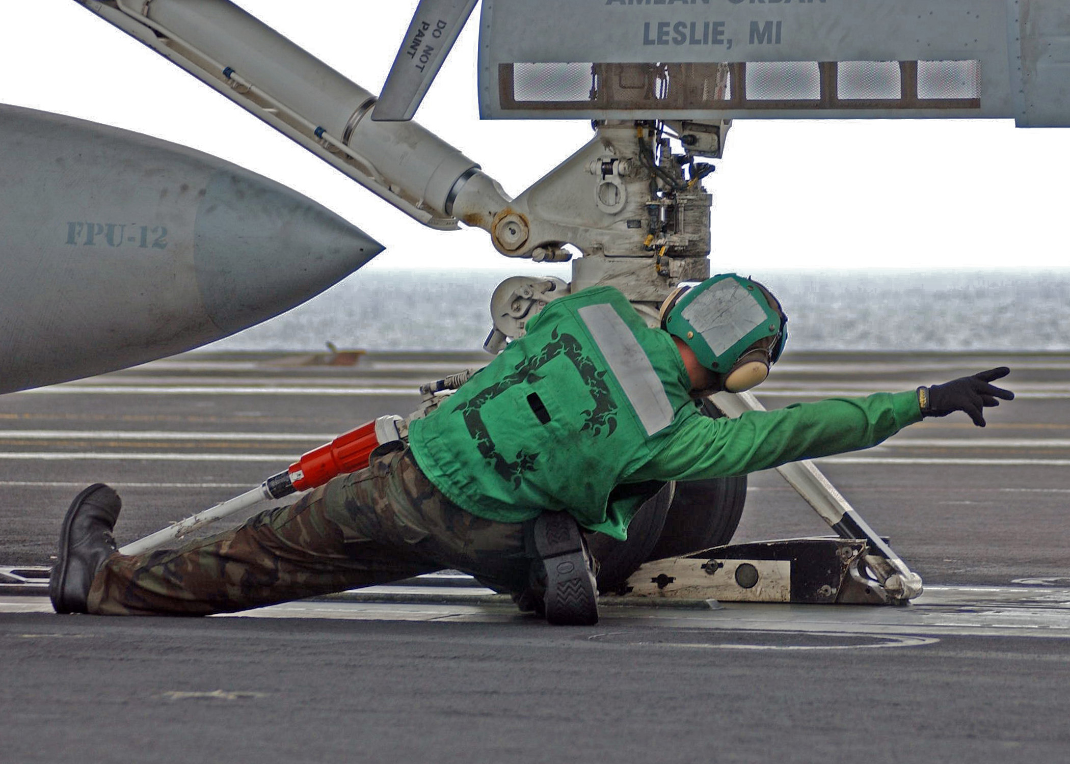 A V-2 Division catapult crew does a final inspection of the launching apparatus, and gives the 'go ahead' signal.