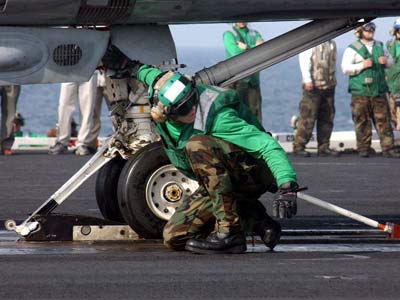 A V-2 Catapult crewman does a preliminary inspection of the launching apparatus.