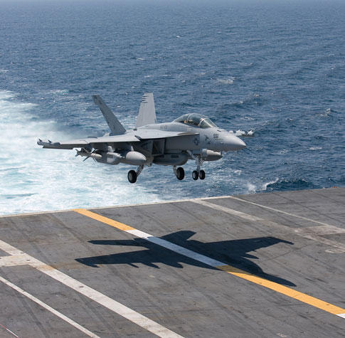 An F/A-18 Super Hornet approaching the deck to land.
