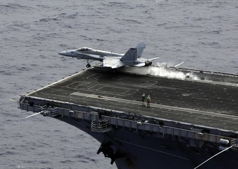 An F/A-18 Hornet launches off of the bow of the USS Kitty Hawk.