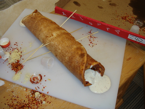 A rolled pizza, with ranch dressing.