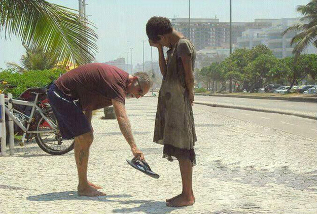 man giving his shoes to a homeless girl