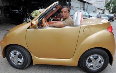 Cambodian mechanic Nhean Phaloek sits in his self-designed home-made Angkor 333-2010 car at his house in Phnom Penh. The gold-coloured convertible turns heads on impoverished Cambodia's roads -- not least because of creator Nhean Phaloek's outlandish claim that it can be operated telepathically.