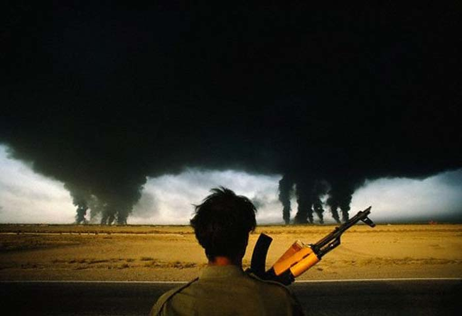 Iranian soldiers looks at the burning Iraqi oil fields.