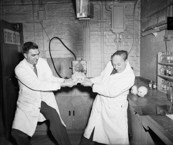 Two factory workers try to make a Halloween mask bigger before boss finds out they messed up the measurements, only 299,999 more to go, 1953.