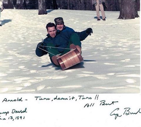 Arnold Schwarzenegger and then President George Bush go for a sled ride, 1991.
