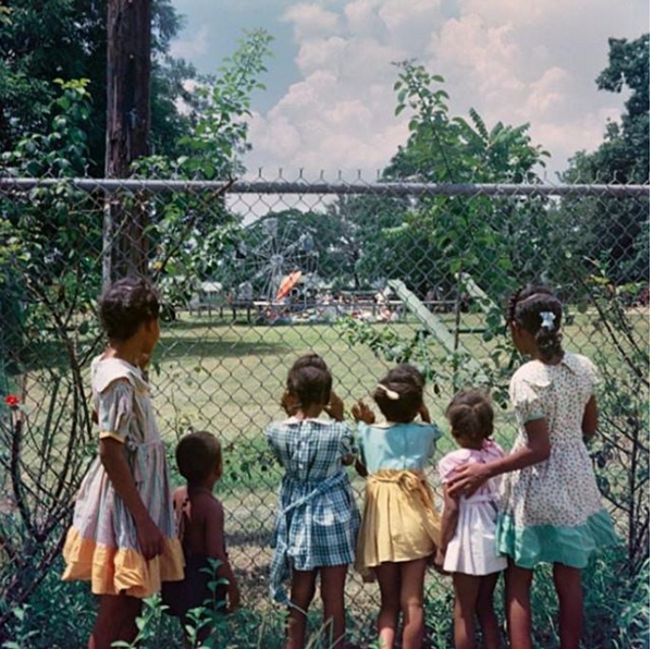 Black children watching as white children play in a whites only park, 1956. Photograph by Gordon Parks.