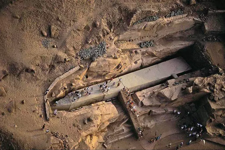An Unfinished Obelisk. This obelisk was carved directly from bedrock, but after cracks appeared in granite, building of the obelisk was abandoned. This is in Egypt and you can see how huge it is by the little human figures.