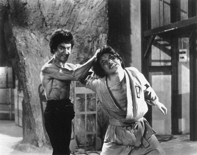Neatly shaven Bruce Lee fighting Jackie Chan in “Enter The Dragon” - 1979