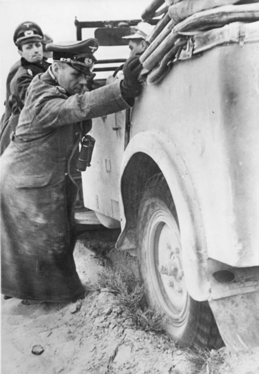 Erwin Rommel helps to push his stuck staff car somewhere in Northern Africa, 1941.