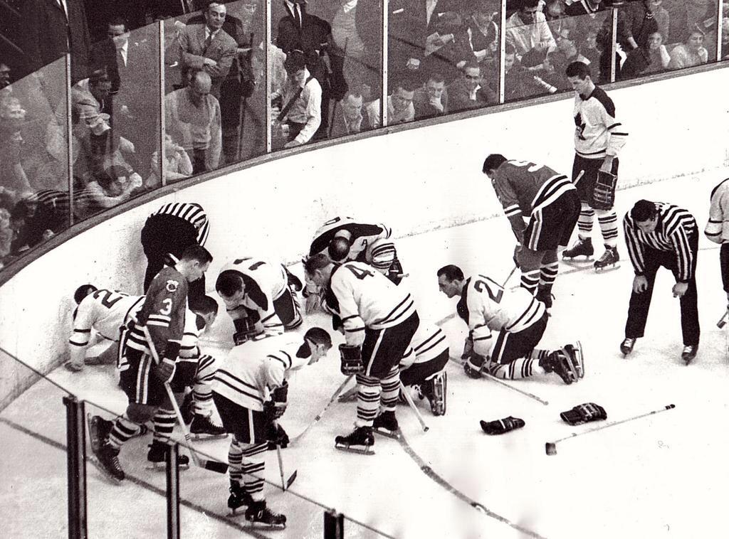 Players from two hockey teams search for any fucks given by Jack Evans, 1962.
