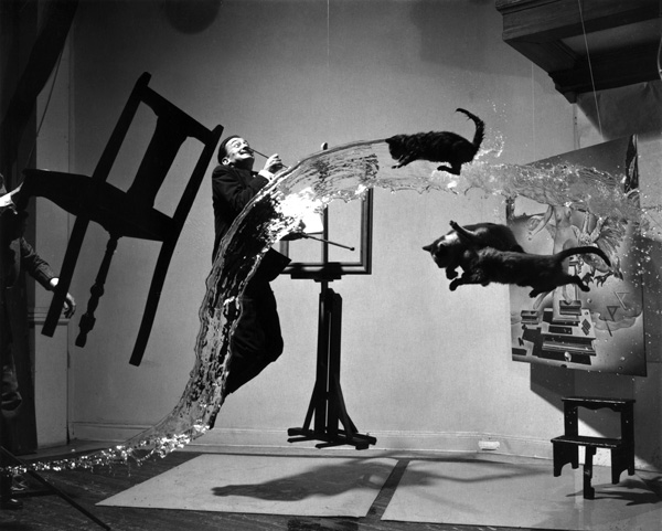 Famous "Dali and Cats" picture. Dali jumped in the air, his assistants threw cats in the air, emptied a bucket of water of said cats, and one clearly visible assistant held up a chair. It took six hours of jumping, moping up, and calming down the cats before this photo was made, 1948.