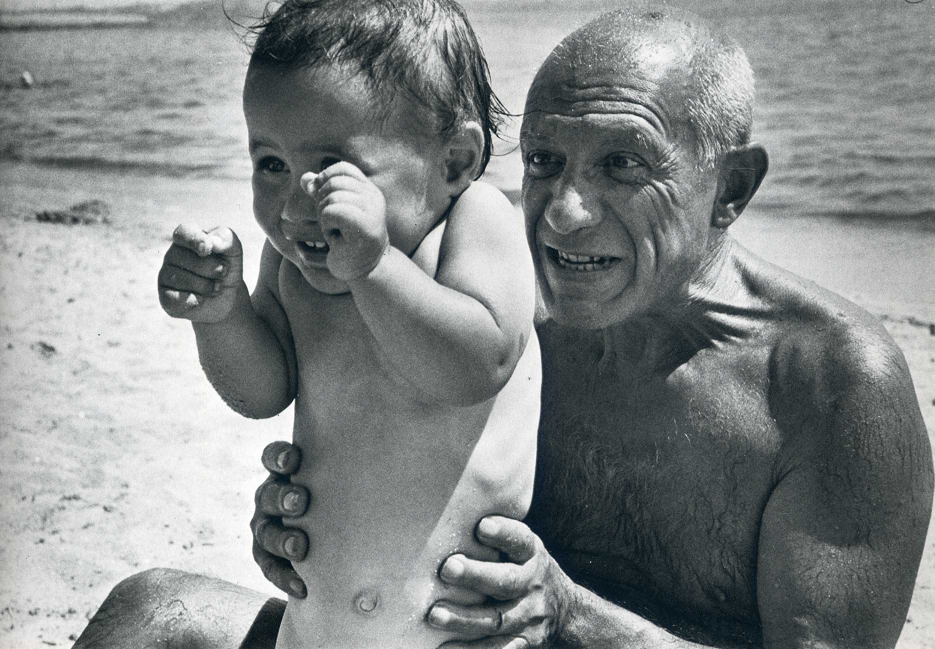 Pablo Picasso playing on the beach with his son