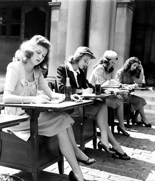 A group of 1940s students doing their schoolwork while drinking some Coca Cola.