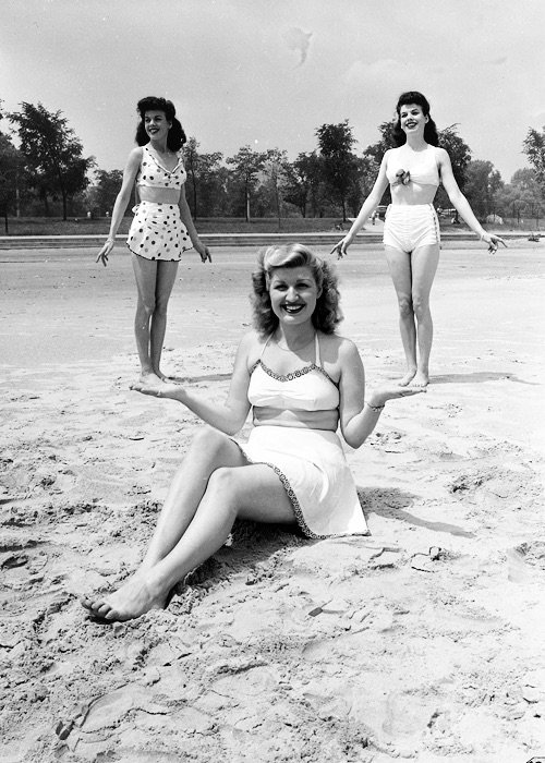 Cool camera trick with perspective makes it seem that the woman in the center in holding the other two, 1945.