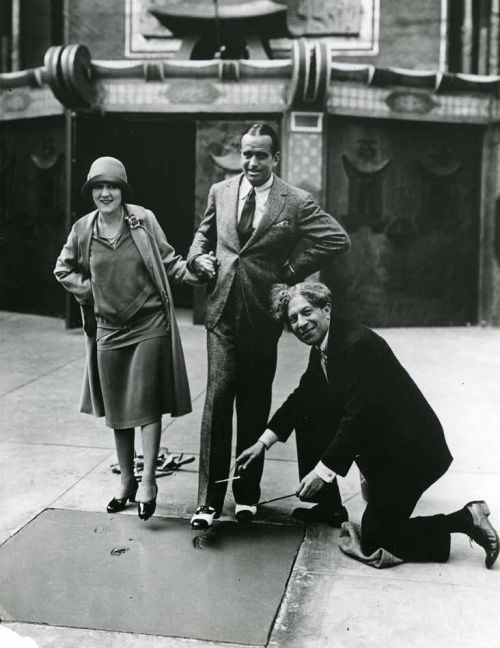 Douglas Fairbanks and Mary Pickford leaving footprints in wet concrete, 04 30 1927. They had to hurry before road workers came back from lunch to discover someone ruined 5 hours of their work.