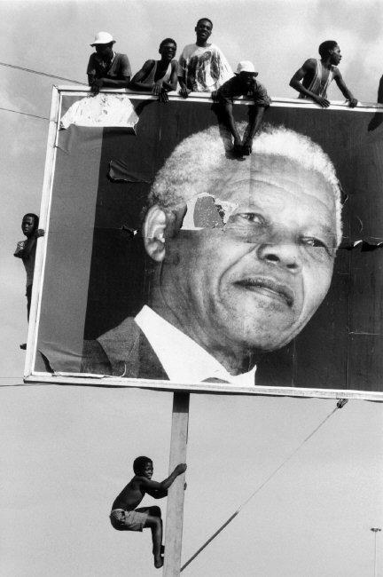 Supporters climbing an election board while waiting for Nelson Mandela in a Natal township, 1994.
