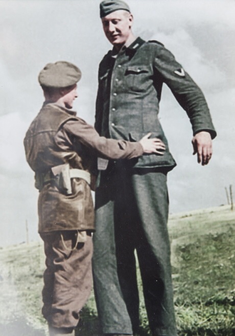A British soldier with a 7ft tall German soldier, 1944.