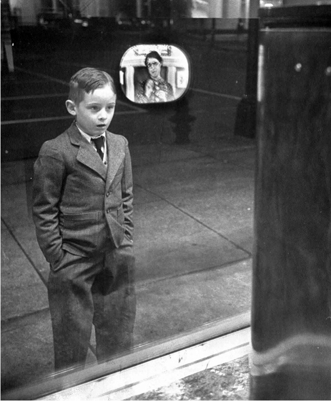 A boy watches television for the first time through a shop window, 1948.