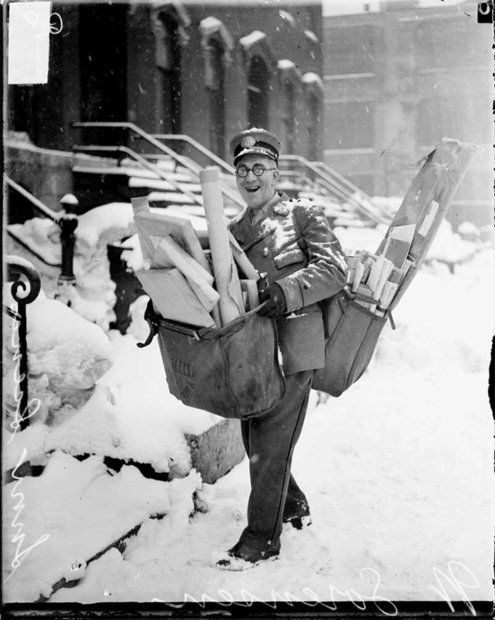 Mailman poses with many letters and parcels, Chicago, Christmas 1929.