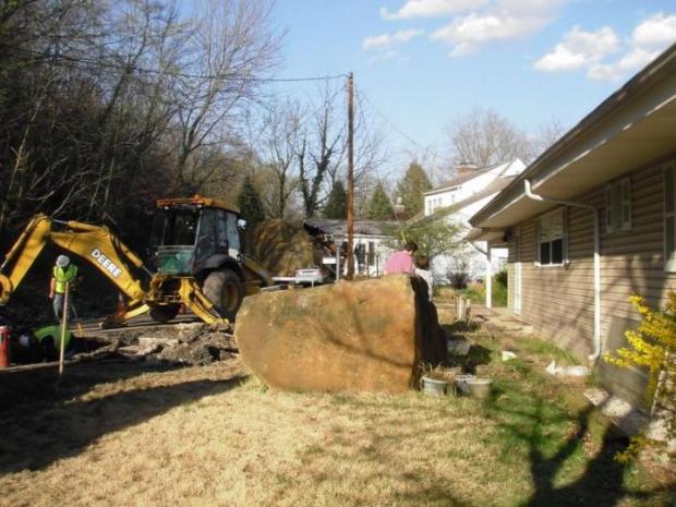 A boulder tumbled down an Ohio hillside, ripping out utility lines before crushing two cars and stopping on the house.