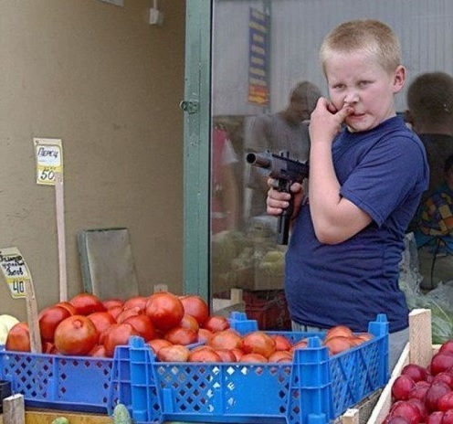 russia - kid holding a gun while selling fruit